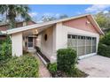 Exterior view of a home featuring a garage, walkway, and well-maintained landscaping at 8188 Forest Oaks Blvd, Spring Hill, FL 34606