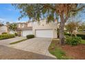 Tan two-story townhome with attached garage and landscaping at 290 Valencia Cir, St Petersburg, FL 33716