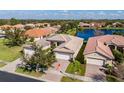 Beautiful single-story home with a two-car garage, lush lawn, and gorgeous lake view at 16233 Amethyst Key Dr, Wimauma, FL 33598