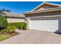 Home exterior featuring a brick driveway, two car garage, and well-maintained landscaping at 16233 Amethyst Key Dr, Wimauma, FL 33598