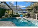 Inviting screened pool area with waterfall feature, lounge chairs, and basketball hoop at 4827 Queen Palm Ne Ter, St Petersburg, FL 33703