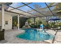 Relaxing kidney-shaped pool with a screened enclosure and stone patio at 4827 Queen Palm Ne Ter, St Petersburg, FL 33703