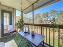 Relaxing screened balcony with comfortable chair, table and natural green view at 9100 Dr Martin Luther King Jr N St # 516, St Petersburg, FL 33702