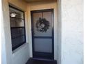 Condo entrance with screen door and holiday wreath at 14130 Rosemary Ln # 2102, Largo, FL 33774