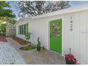 White house with a bright green door and brick walkway at 1428 Illinois Ave, Palm Harbor, FL 34683