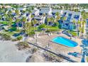 Aerial view of beachside community with pool and lush landscaping at 2100 Gulf Blvd # 13, Belleair Beach, FL 33786