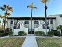 Front view of two-story building with palm trees and walkway at 4452 Weybridge St # 74, Sarasota, FL 34235