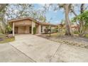 Single-story home with covered carport, manicured lawn, and mature trees in a tranquil setting at 5110 28Th W St, Bradenton, FL 34207