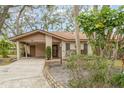 Charming single-story home with a covered carport surrounded by lush greenery and landscaped features at 5110 28Th W St, Bradenton, FL 34207