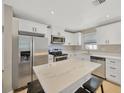 Updated kitchen with white cabinets, quartz countertops, and island at 6598 26Th N St, St Petersburg, FL 33702