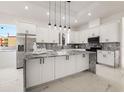 Modern kitchen with white cabinets, marble countertops, and island at 2513 W Hiawatha St, Tampa, FL 33614