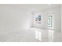 Bright living room featuring marble-look floors and a view to the front yard at 2513 W Hiawatha St, Tampa, FL 33614