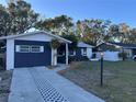 Newly renovated home with a charming curb appeal, featuring a fresh coat of paint and landscaping at 5703 S Sheridan Rd, Tampa, FL 33611