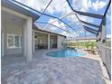 Covered outdoor living space next to a screened-in pool and spa with paver patio at 11213 Warm Wind Way, Weeki Wachee, FL 34613
