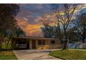Inviting single-story home with a covered parking, a neat lawn, and a driveway at 4145 Harrisburg Ne St, St Petersburg, FL 33703