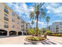 Community courtyard with fountain, palm trees, and brick pavement at 501 Knights Run Ave # 1217, Tampa, FL 33602