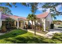 Villa with red tile roof, walkway, and lush landscaping at 1120 Tartan Dr, Palm Harbor, FL 34684