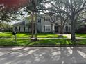 Two-story home with gray siding, stone accents, and a landscaped lawn at 4202 W Culbreath Ave, Tampa, FL 33609