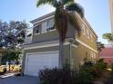 Side view of a two-story house with gray siding and white garage door at 6519 Simone Shores Cir, Apollo Beach, FL 33572