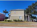 Side view of a tan two-story house with white trim at 6519 Simone Shores Cir, Apollo Beach, FL 33572