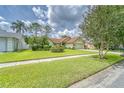 Green house with red tile roof, well-manicured lawn, and mature landscaping at 9719 Pleasant Run Way, Tampa, FL 33647