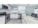 Renovated kitchen with white cabinets, granite counters, and stainless steel appliances at 4051 30Th N Ave, St Petersburg, FL 33713