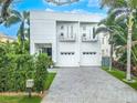 Modern two-story home with white exterior, two-car garage, and landscaped front yard at 2711 W Trilby Ave, Tampa, FL 33611