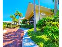 Exterior shot of the building with tropical landscaping and a brick driveway at 611 Destiny Dr # 207, Ruskin, FL 33570