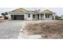 New construction home with gray siding, paver driveway, and a yellow accent at 142 Fairway Rd, Rotonda West, FL 33947