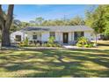 Single story home with covered porch and lush landscaping at 12308 N 53Rd St, Temple Terrace, FL 33617