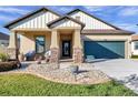 House exterior showcasing a two-car garage, manicured lawn, and inviting porch at 21489 Billowy Jaunt Dr, Land O Lakes, FL 34637