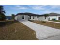 New gray house with gray pavers driveway and landscaping at 10402 Pendleton Ave, Englewood, FL 34224