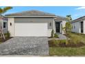 Two-car garage and walkway leading to the front entrance of a modern home at 11170 Livewell Ct, Venice, FL 34293