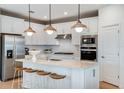 Modern kitchen with white cabinets, quartz countertops, and stainless steel appliances at 9820 Crescent Moon Dr, Riverview, FL 33578