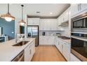 Modern kitchen with white cabinets, quartz countertops, and stainless steel appliances at 9820 Crescent Moon Dr, Riverview, FL 33578