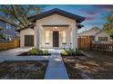 White house with black roof and front porch at dusk at 1565 13Th S St, St Petersburg, FL 33705