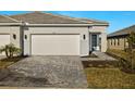 Front view of house with a paved driveway and landscaping at 11267 Boundless Ter, Venice, FL 34293