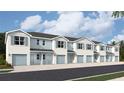 A row of beautiful townhomes featuring a two-car garage, light blue accents, and a well-maintained yard at 4600 Stargazer Ct, Palm Harbor, FL 34683