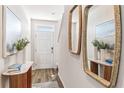 Inviting entryway featuring light wood floors, console table, and stylish decor at 4653 Pleasant Ave, Palm Harbor, FL 34683