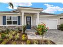 Inviting entrance showcasing a front yard, walkway, manicured landscaping, and blue door at 17909 Solstice Ave, Venice, FL 34293