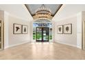 Bright foyer featuring a modern chandelier, herringbone wood floors, and double glass doors to the front yard at 16407 Zurraquin De Avila, Tampa, FL 33613