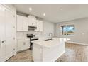 Bright, modern kitchen featuring white cabinetry, stainless steel appliances, and a central island at 17938 Solstice Ave, Venice, FL 34293