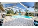 Sparkling pool enclosed in a screened lanai with paved patio, providing a relaxing outdoor space at 1575 Wicklow Dr, Palm Harbor, FL 34684