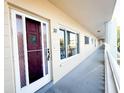 Exterior hallway featuring unit 30 with a storm door and a view of the surrounding property at 2330 Ecuadorian Way # 30, Clearwater, FL 33763