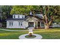 Renovated brick home featuring a large oak tree and landscaped yard at 37439 Meridian Ave, Dade City, FL 33525