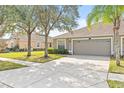 Two-car garage with a neatly landscaped front yard at 4427 Ashton Meadows Way, Wesley Chapel, FL 33543