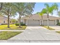 Three-unit building with attached garages and lush landscaping at 4427 Ashton Meadows Way, Wesley Chapel, FL 33543