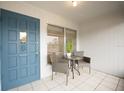 Inviting front porch featuring a blue door, neutral outdoor furniture, and bright natural light at 4444 Swift Rd # 20, Sarasota, FL 34231