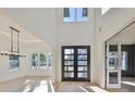 Bright entryway featuring high ceilings, a modern light fixture, and a striking black-framed glass door at 4608 S Ferdinand Ave, Tampa, FL 33611