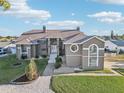 Two-story home with gray stucco, a tile roof, and landscaped grounds at 1020 Bal Harbour Dr, Apollo Beach, FL 33572